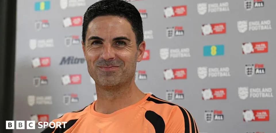 Entrenador sonriendo en conferencia de prensa