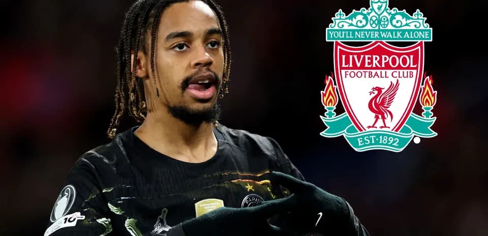 Jugador señalando el escudo del Liverpool FC