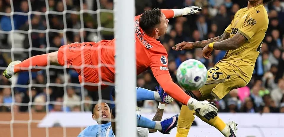 Portero saltando mientras intenta detener el balón