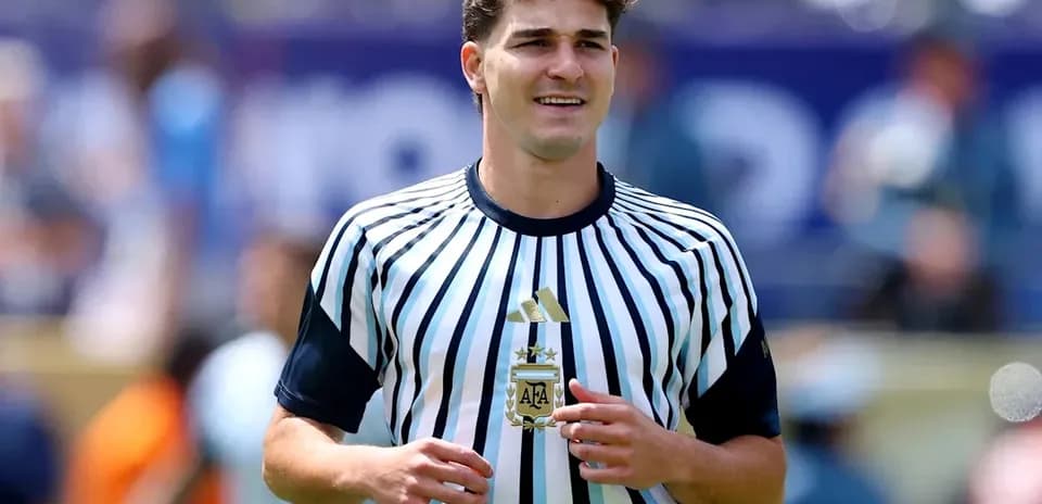 Jugador sosteniendo un balón en uniforme de árbitro