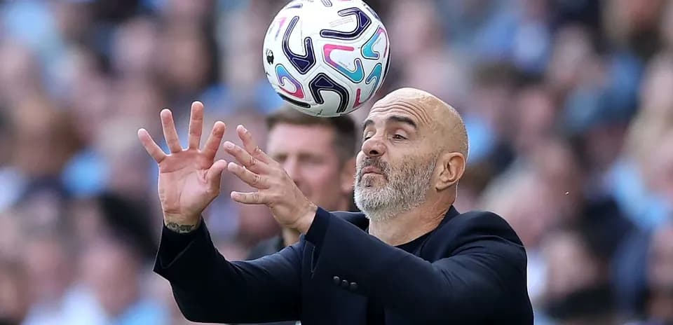 Entrenador intentando atrapar un balón en el campo