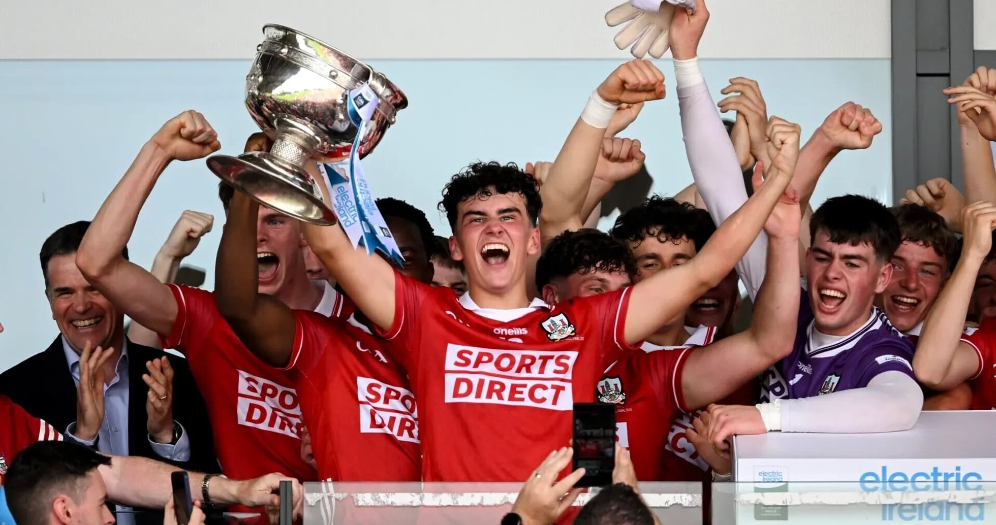 Equipo celebrando con trofeo después de la victoria