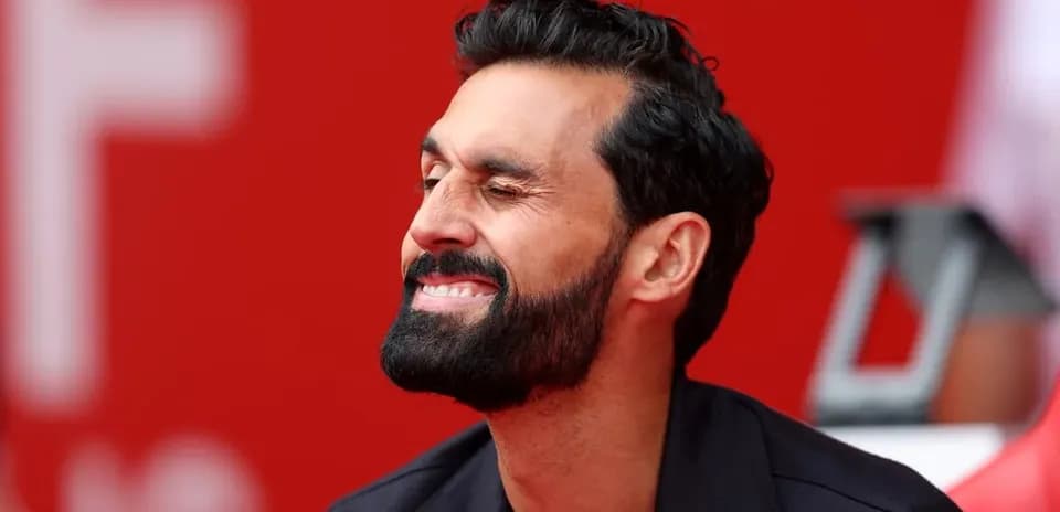 Hombre sonriendo mientras está sentado en un banco