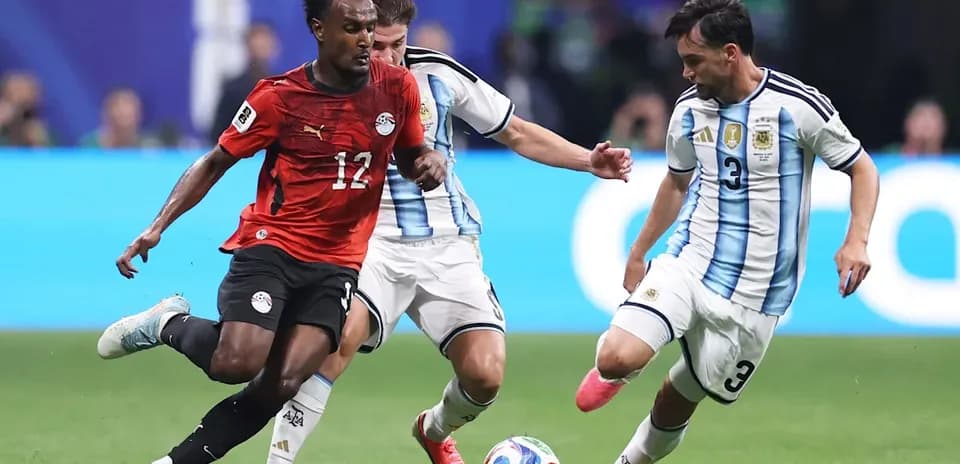 Jugador de Egipto driblando entre dos jugadores argentinos