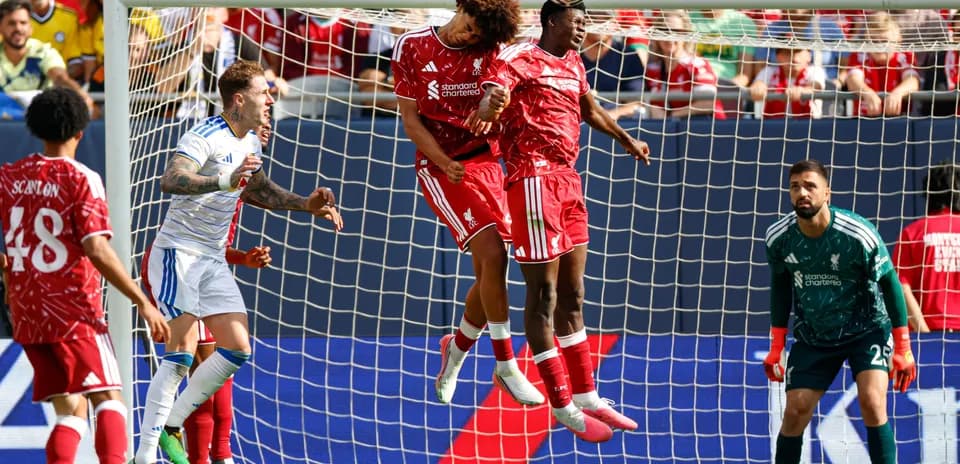 Jugadores de Liverpool saltando para cabecear el balón