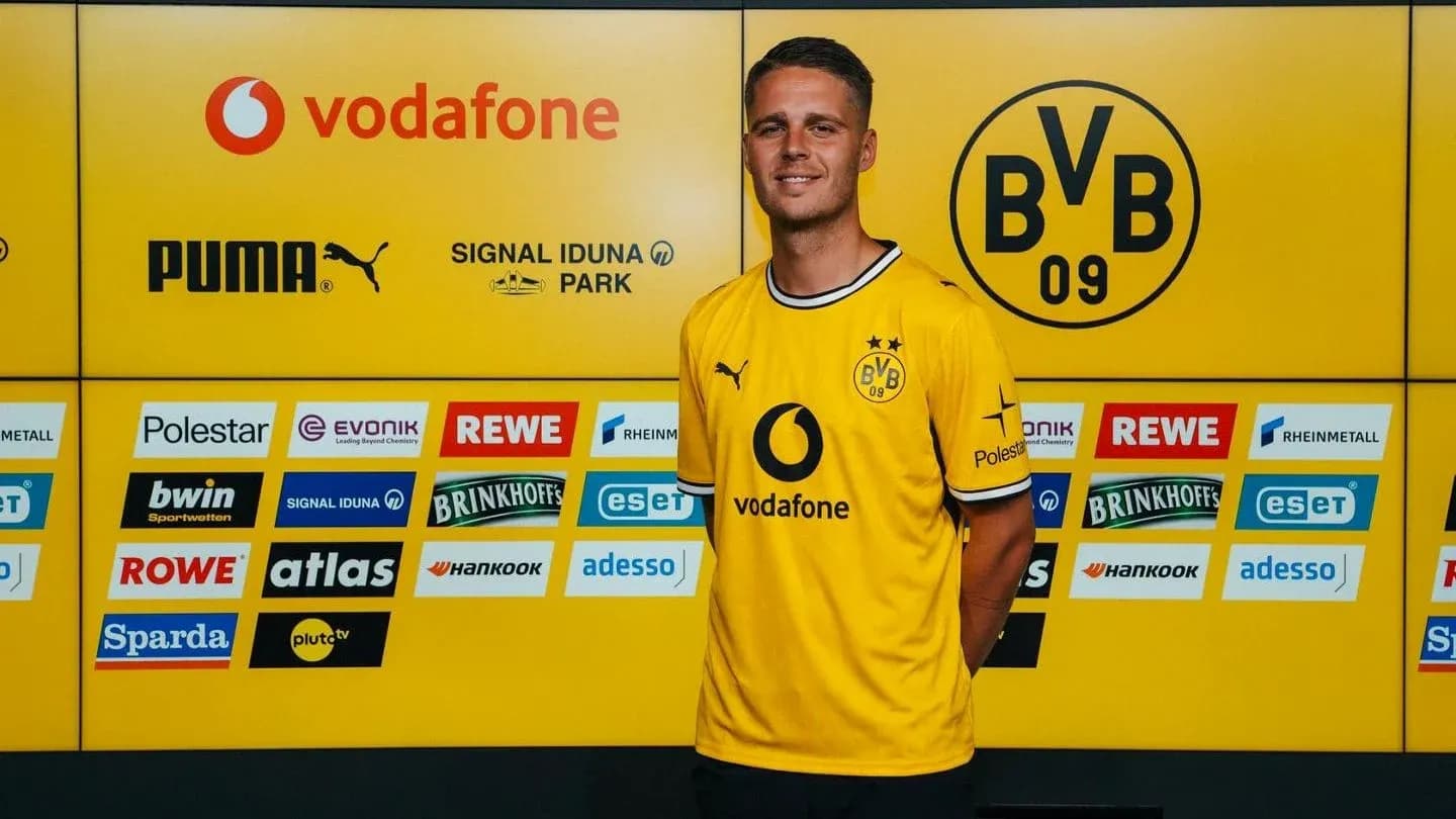 Jugador posando en presentación oficial con camiseta amarilla