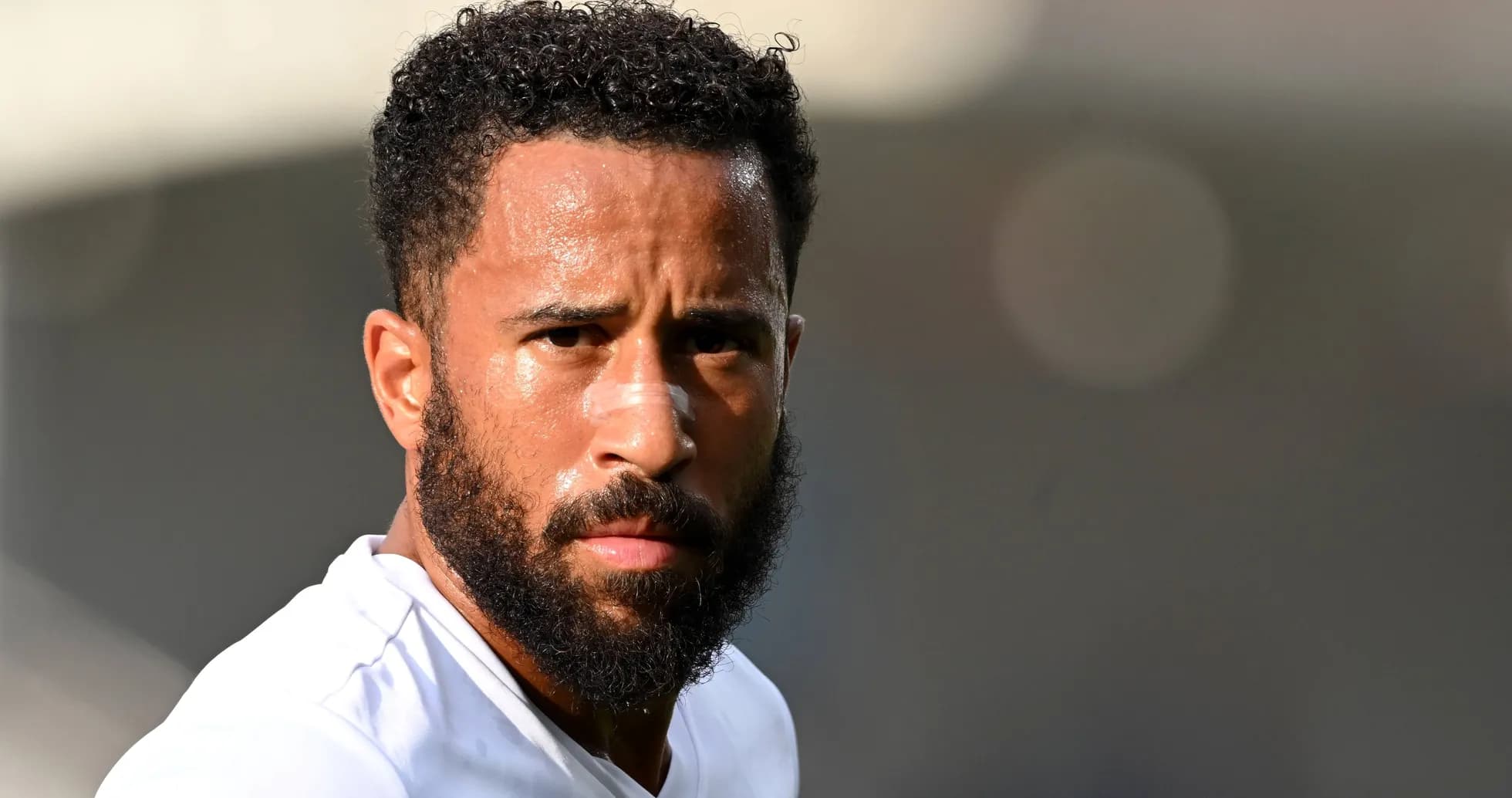 Jugador con barba y camiseta blanca en primer plano