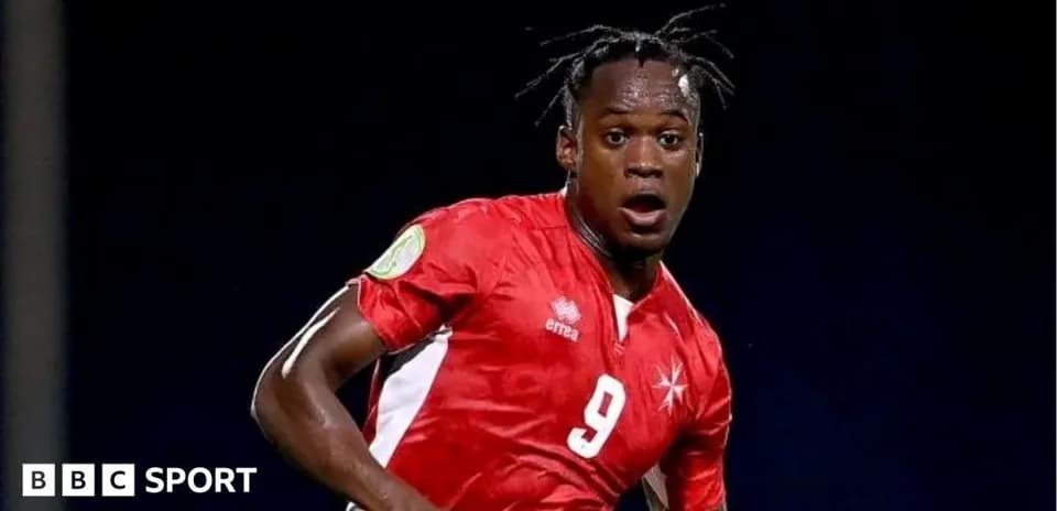 Jugador de fútbol con camiseta roja corriendo en el campo