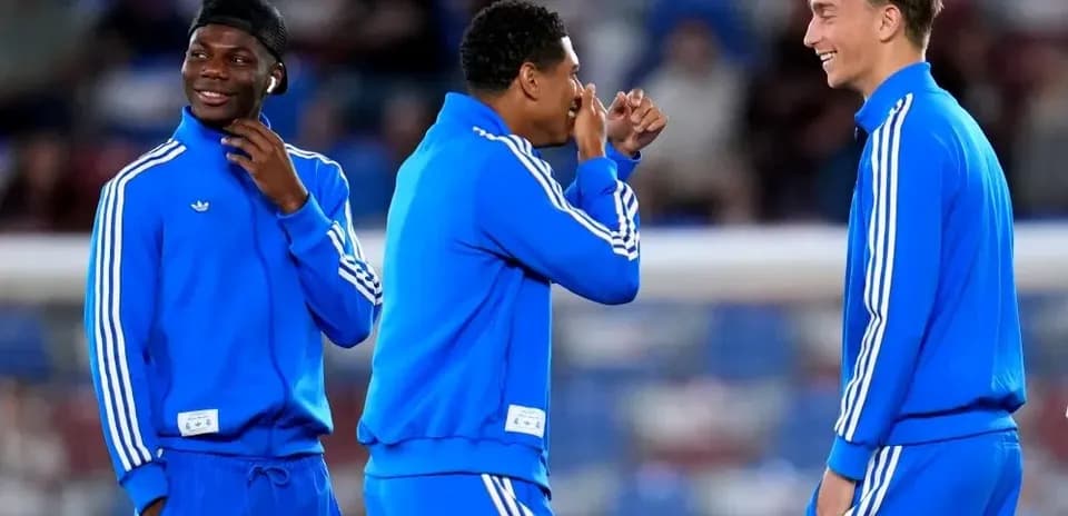 Jugadores en calentamiento con ropa de entrenamiento azul