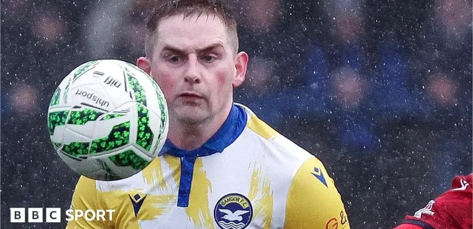 Jugador de Bangor FC controlando el balón en la lluvia