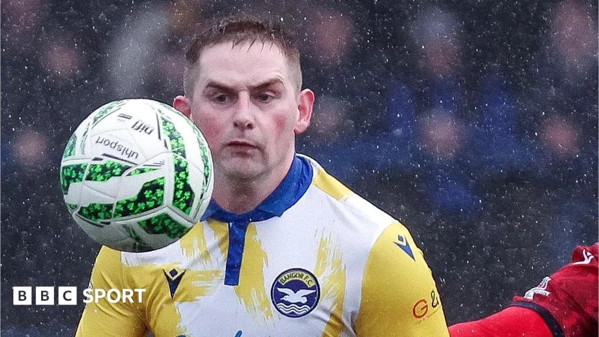 Jugador de Bangor FC controlando el balón en la lluvia