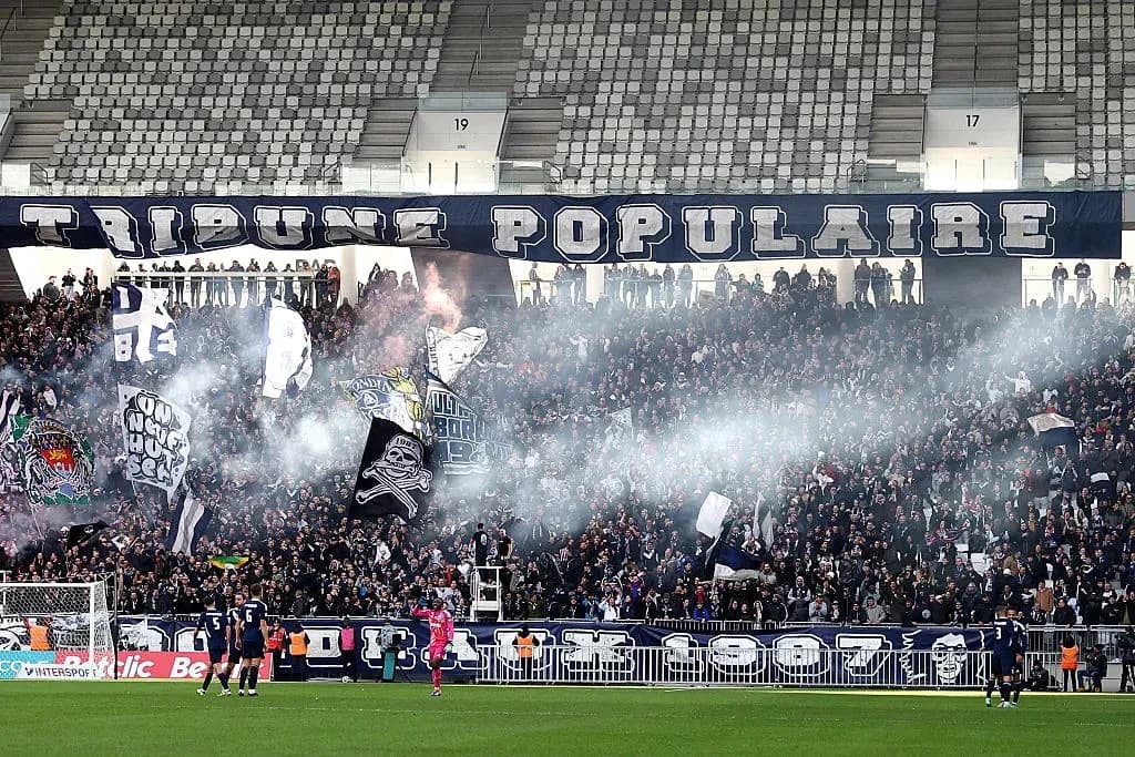 Aficionados con banderas en el estadio lleno de humo