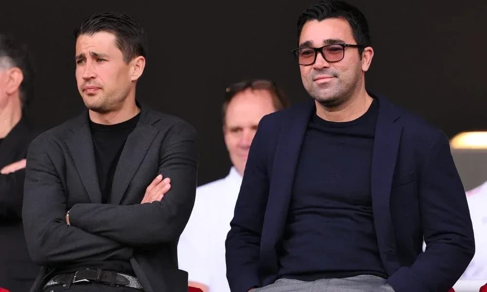 Dos hombres observando un evento deportivo desde las gradas