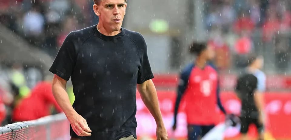 Entrenador caminando por la línea de banda bajo la lluvia