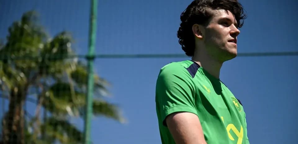 Jugador de fútbol en campo de entrenamiento bajo sol