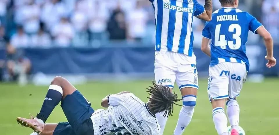 Jugador de Lech Poznan evita a oponente caído