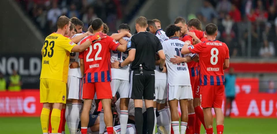 Jugadores de ambos equipos en círculo durante el partido