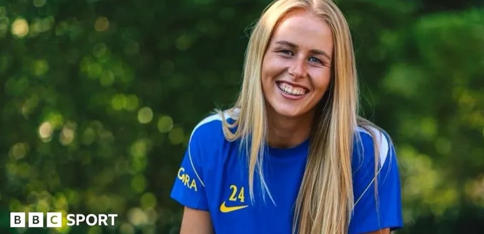 Jugadora sonriente con camiseta azul en entorno natural
