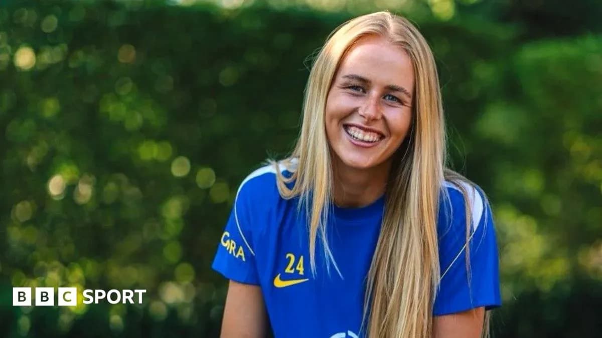 Jugadora sonriente con camiseta azul en entorno natural