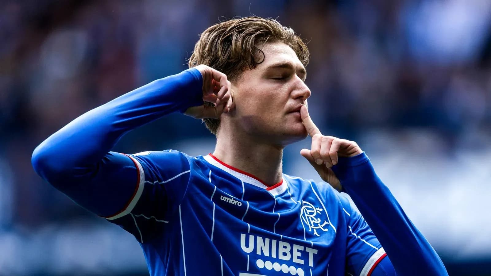 Jugador de Rangers haciendo gesto de silencio tras gol