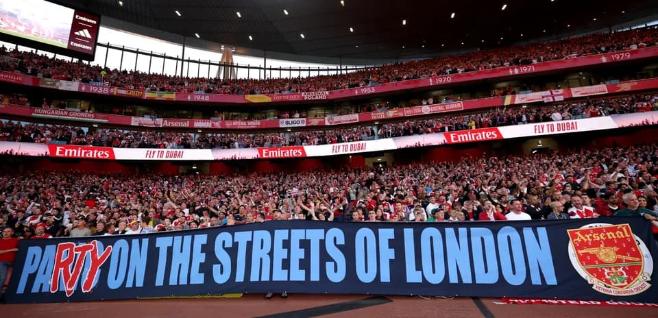 Aficionados de Arsenal sosteniendo una pancarta en el estadio