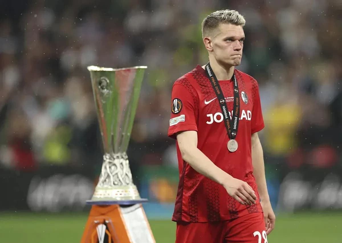 Jugador caminando junto al trofeo de la UEFA Europa League