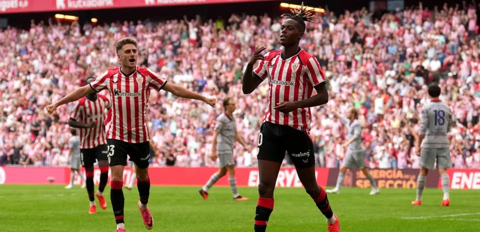 Jugador celebrando un gol con compañeros en el estadio