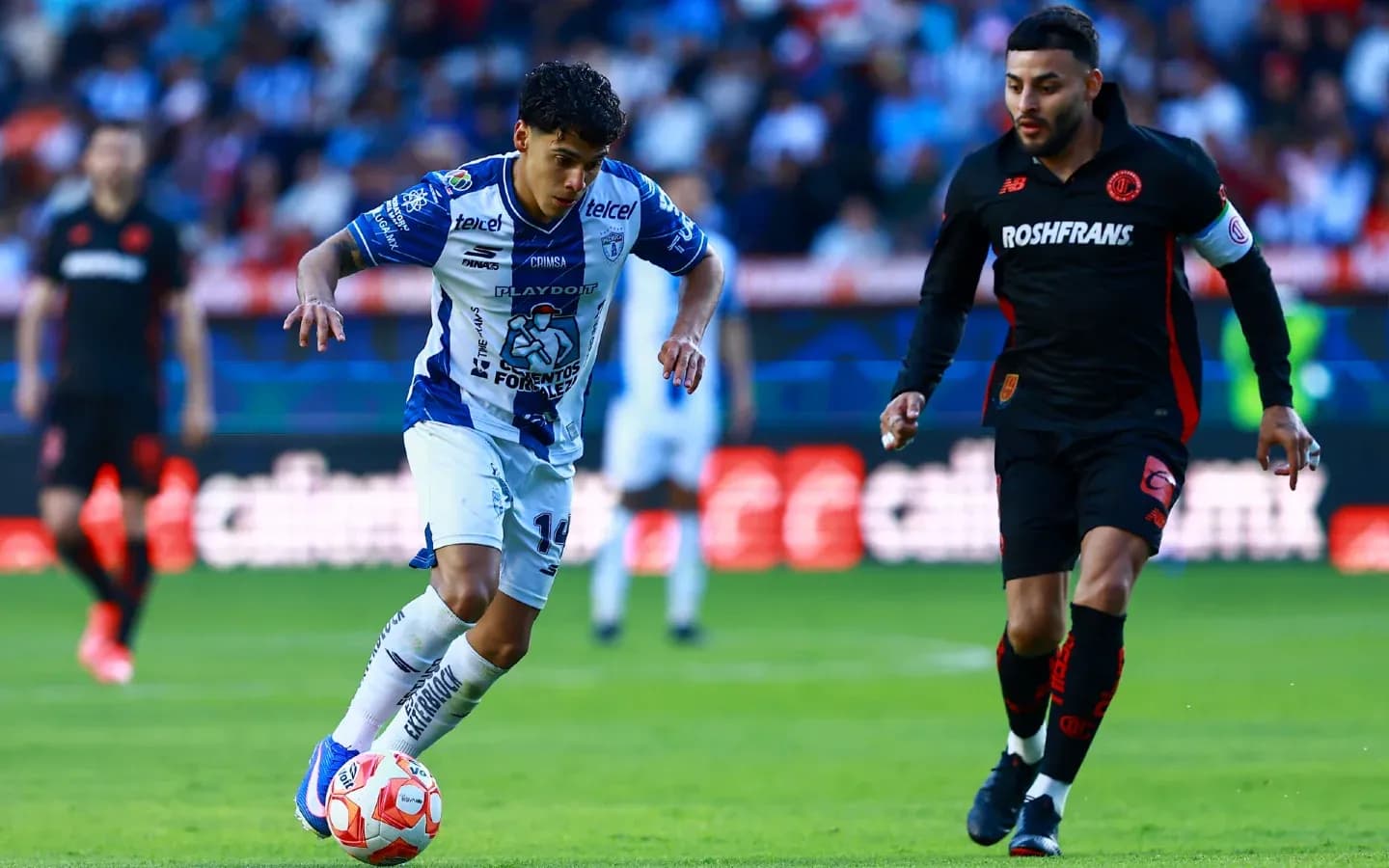 Jugador de Pachuca conduciendo el balón frente a Toluca