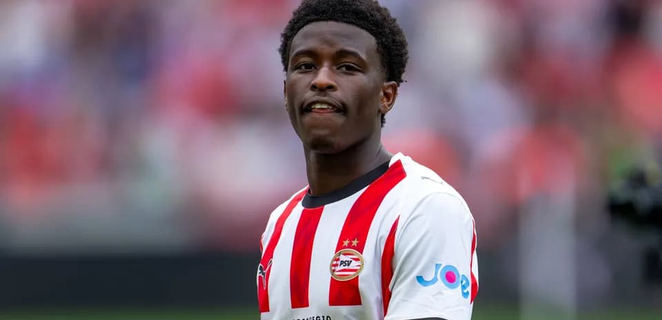 Jugador de PSV con camiseta roja y blanca sonriendo