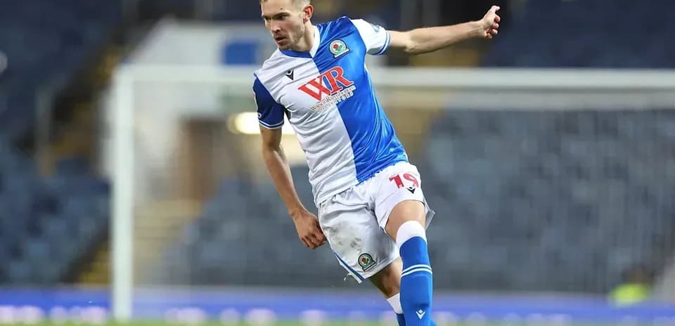 Jugador de Blackburn Rovers pateando el balón en partido