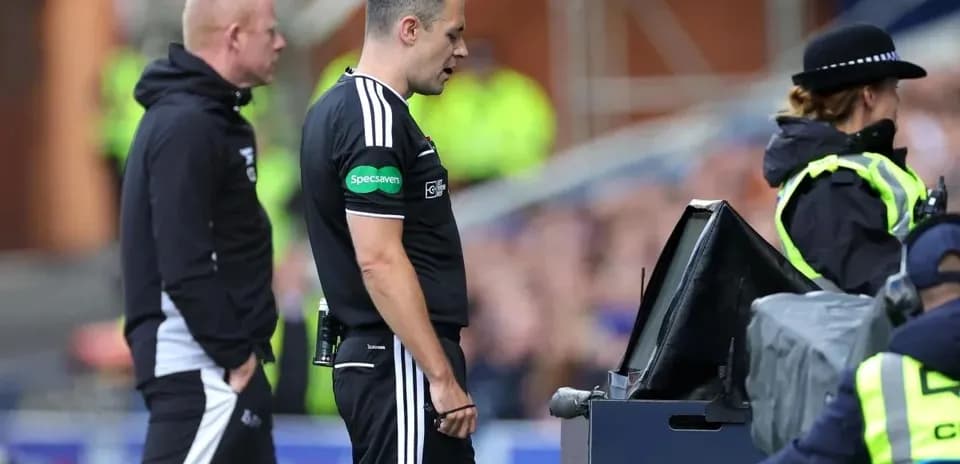 Árbitro revisando jugada en pantalla VAR durante partido
