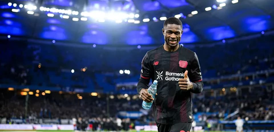 Jugador de fútbol sonriendo en el campo después del partido