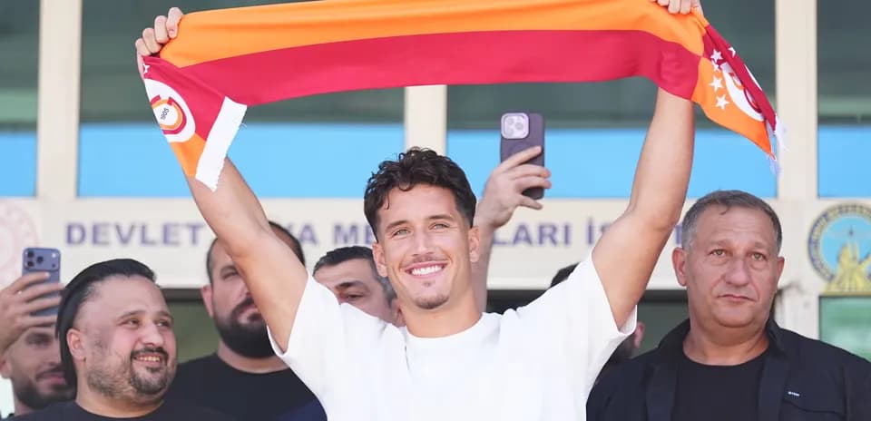 Jugador sosteniendo una bufanda de Galatasaray en presentación