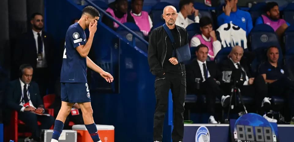 Jugador saliendo del campo y entrenador observando