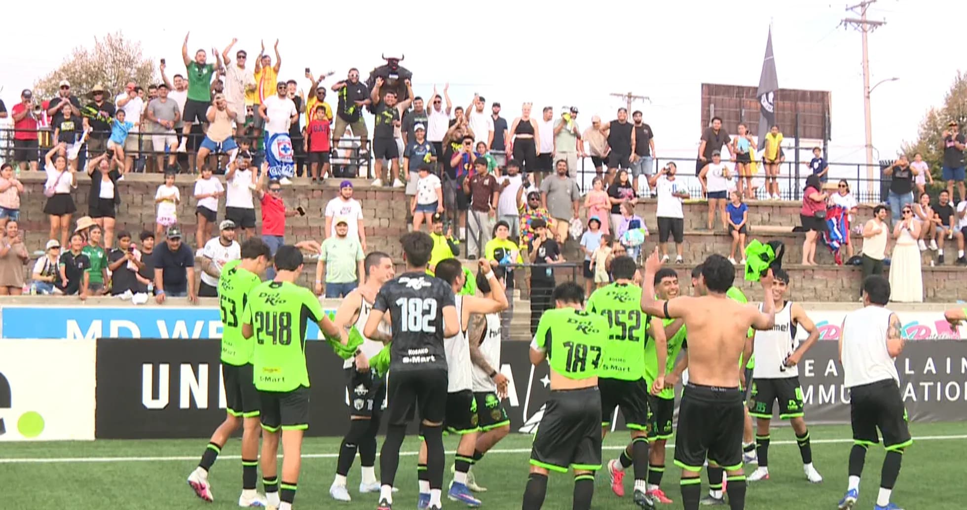 Jugadores celebrando con aficionados en el estadio