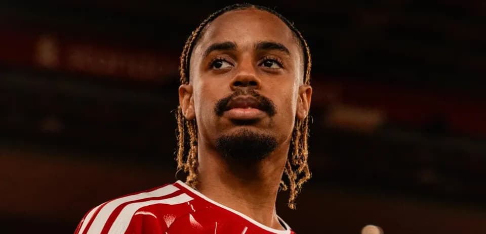 Jugador de fútbol con camiseta roja en estadio