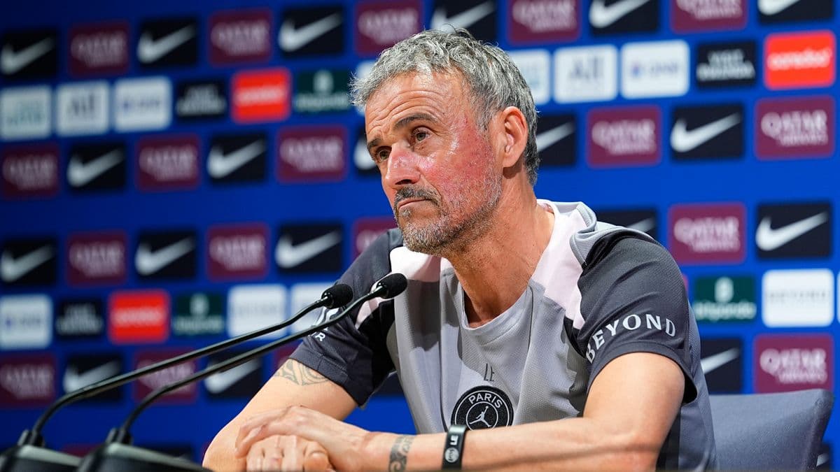 Entrenador en conferencia de prensa con fondo de patrocinadores