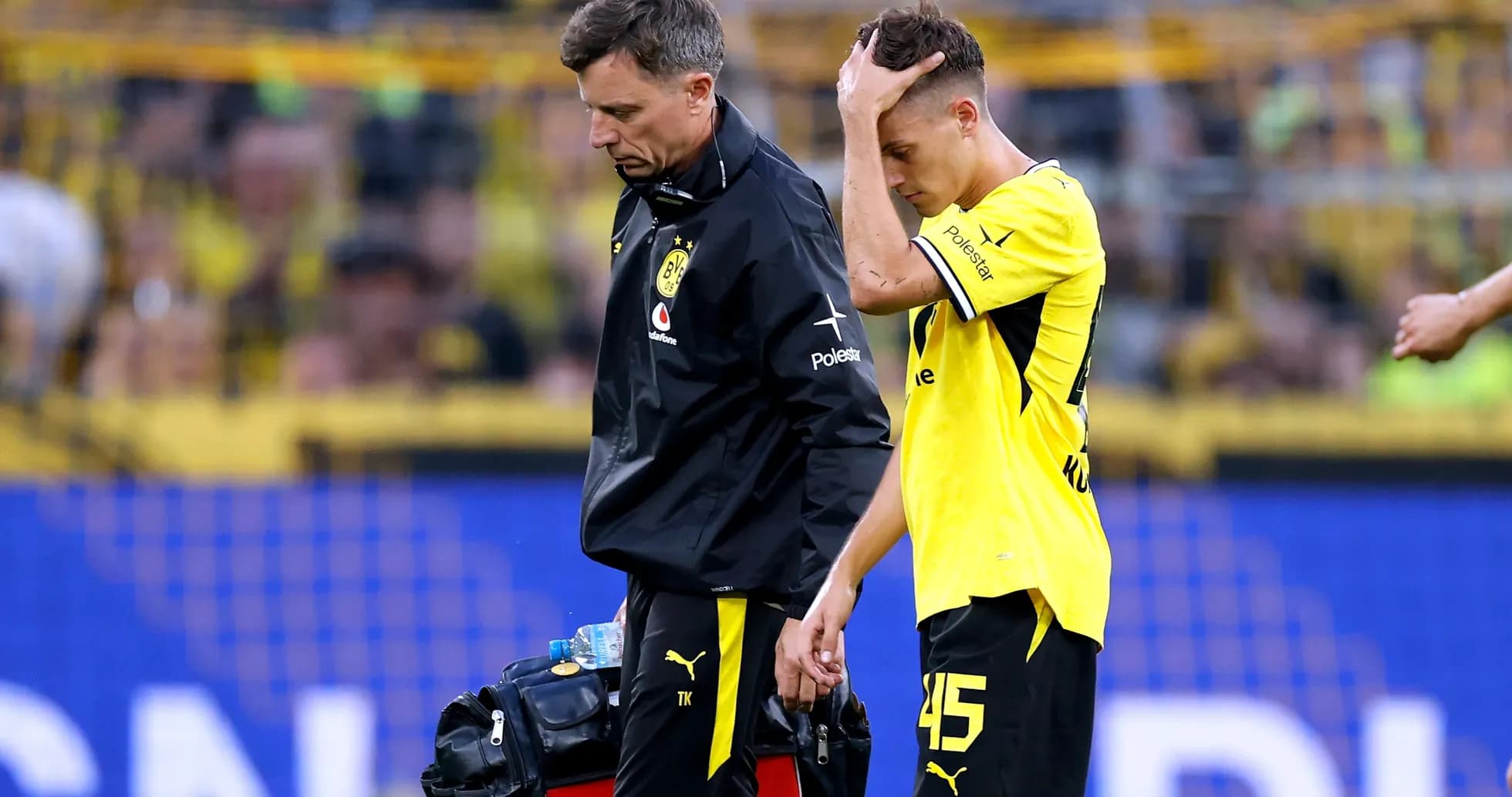 Jugador de Borussia Dortmund saliendo del campo con médico