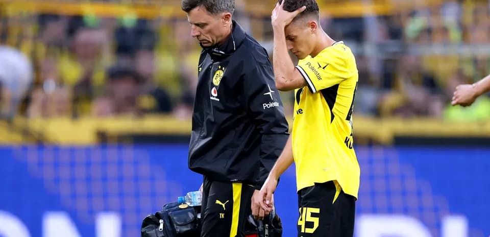 Jugador de Borussia Dortmund saliendo del campo con médico