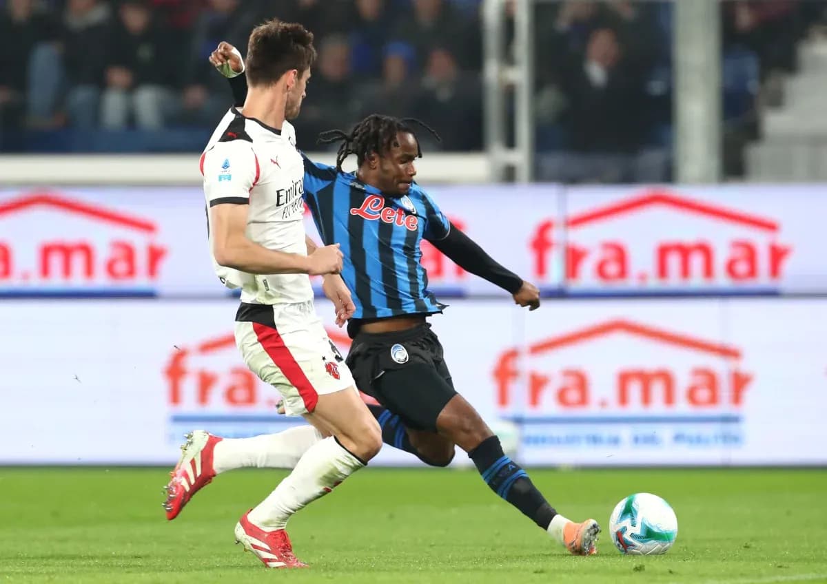 Jugador de Atalanta desafiando a jugador de AC Milan
