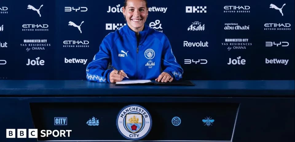 Jugadora firmando contrato en mesa de prensa