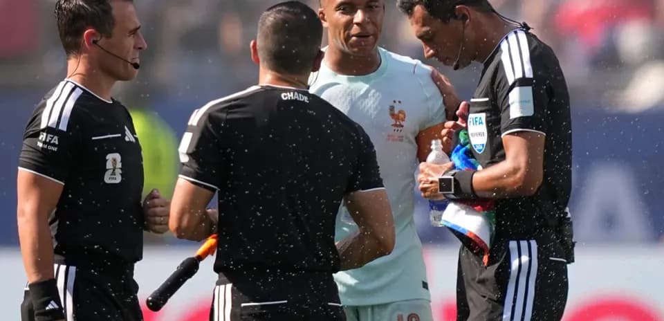 Kylian Mbappé conversando con árbitros durante partido