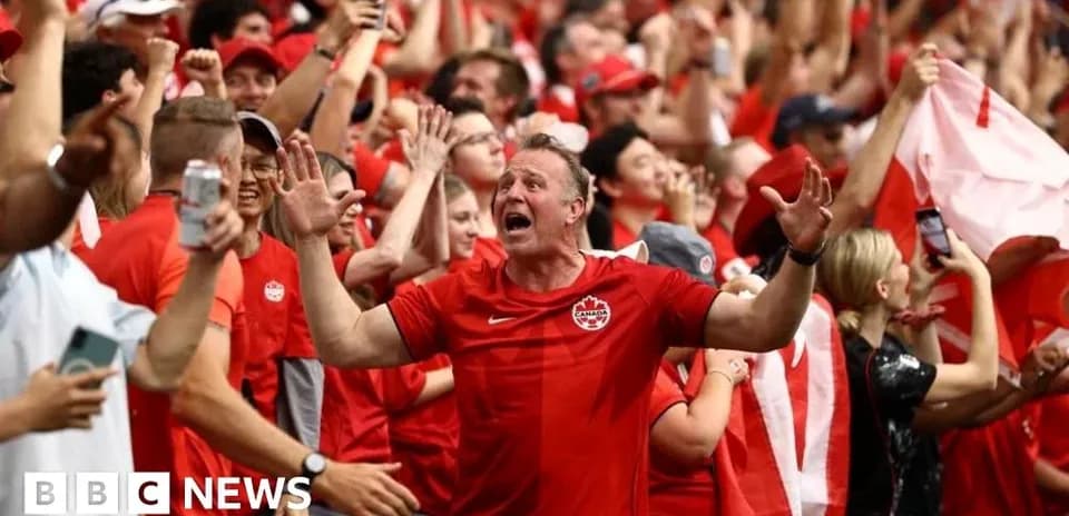 Aficionados animando con camisetas rojas en el estadio