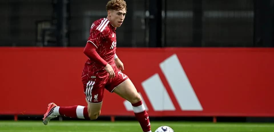 Jugador de Liverpool corriendo con balón en el campo