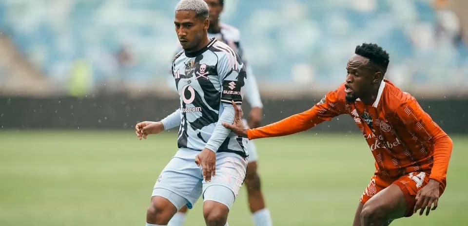 Jugador de fútbol esquivando a un oponente en campo