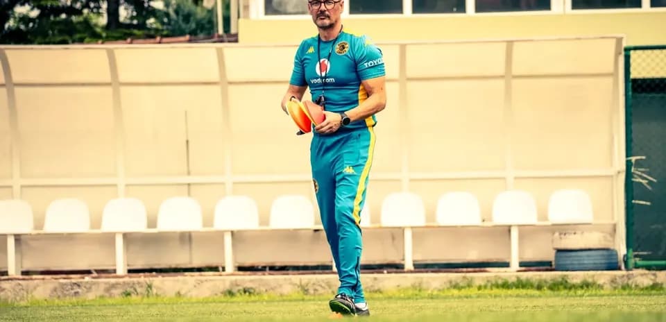 Entrenador caminando con conos de entrenamiento en campo