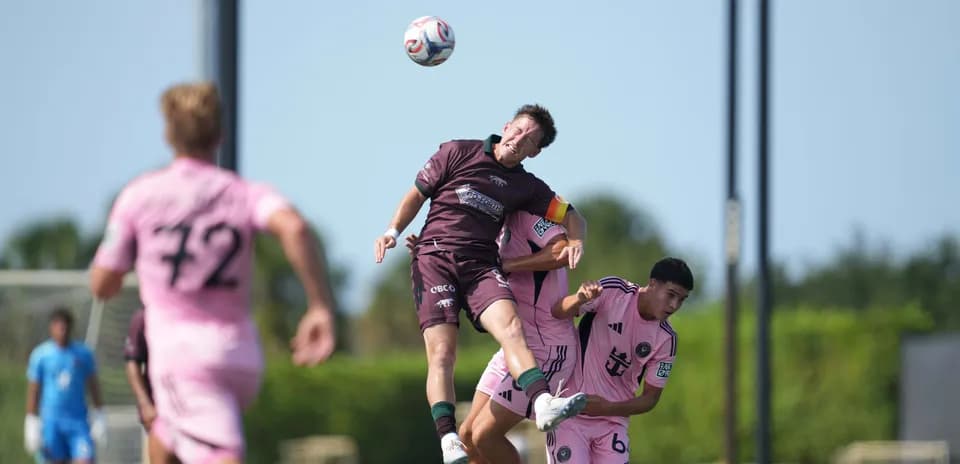 Jugador saltando por el balón en el partido