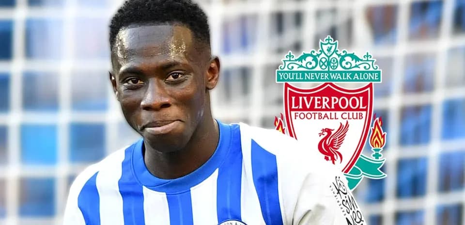 Jugador de Brighton sonriendo frente al logo de Liverpool