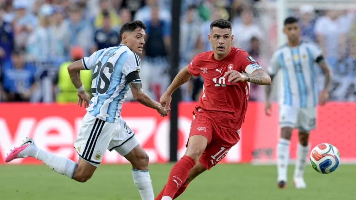 Jugador de Suiza driblando ante defensor argentino en partido
