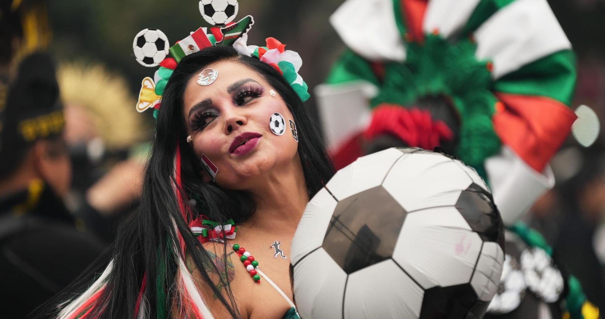 Fan mexicana sosteniendo un balón de fútbol